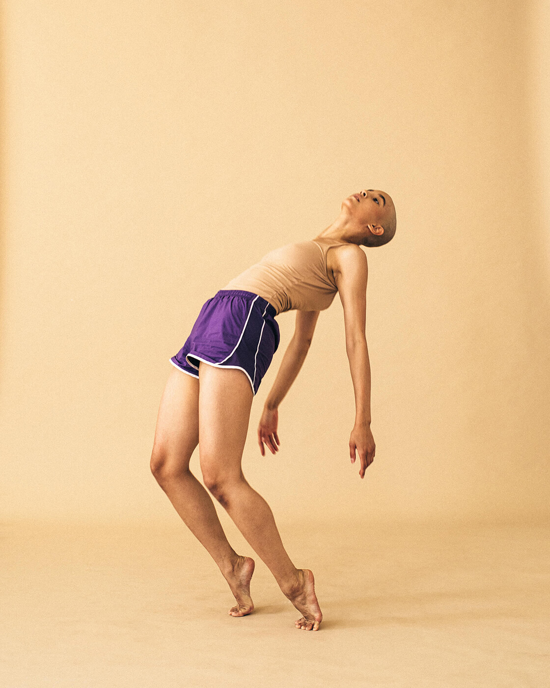 A girl dancing in the studio wearing violet shorts