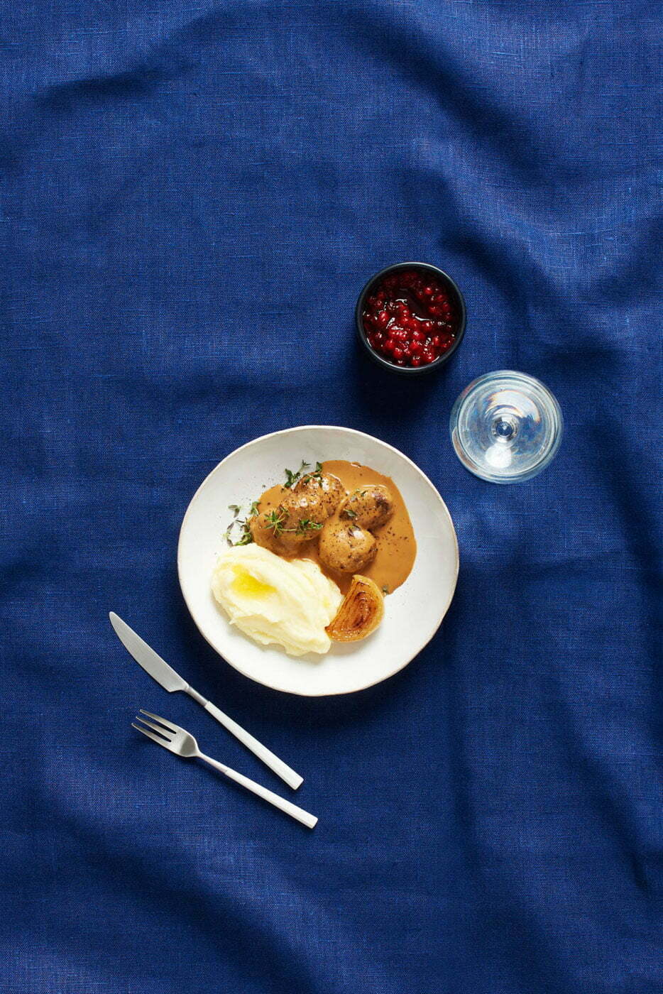 Mashed_potatoes_with_meatballs_and_lingonberries_on_a_blue_tablecloth_by_Elina_Himanen