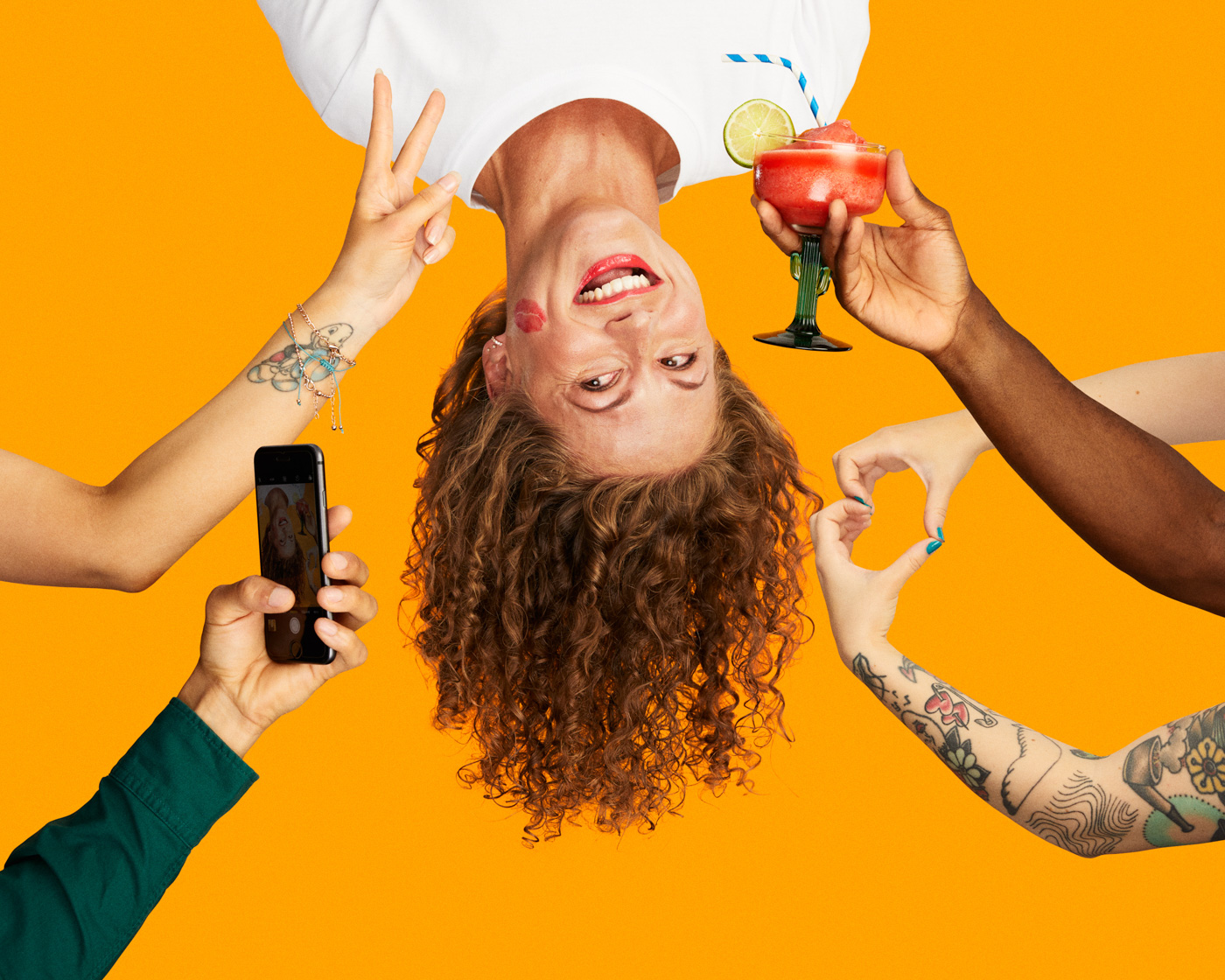 Woman_hanging_upside_down_being_offered_cocktails_and_peace_sign_on_yellow_background_by_Tapio_Ranta-aho