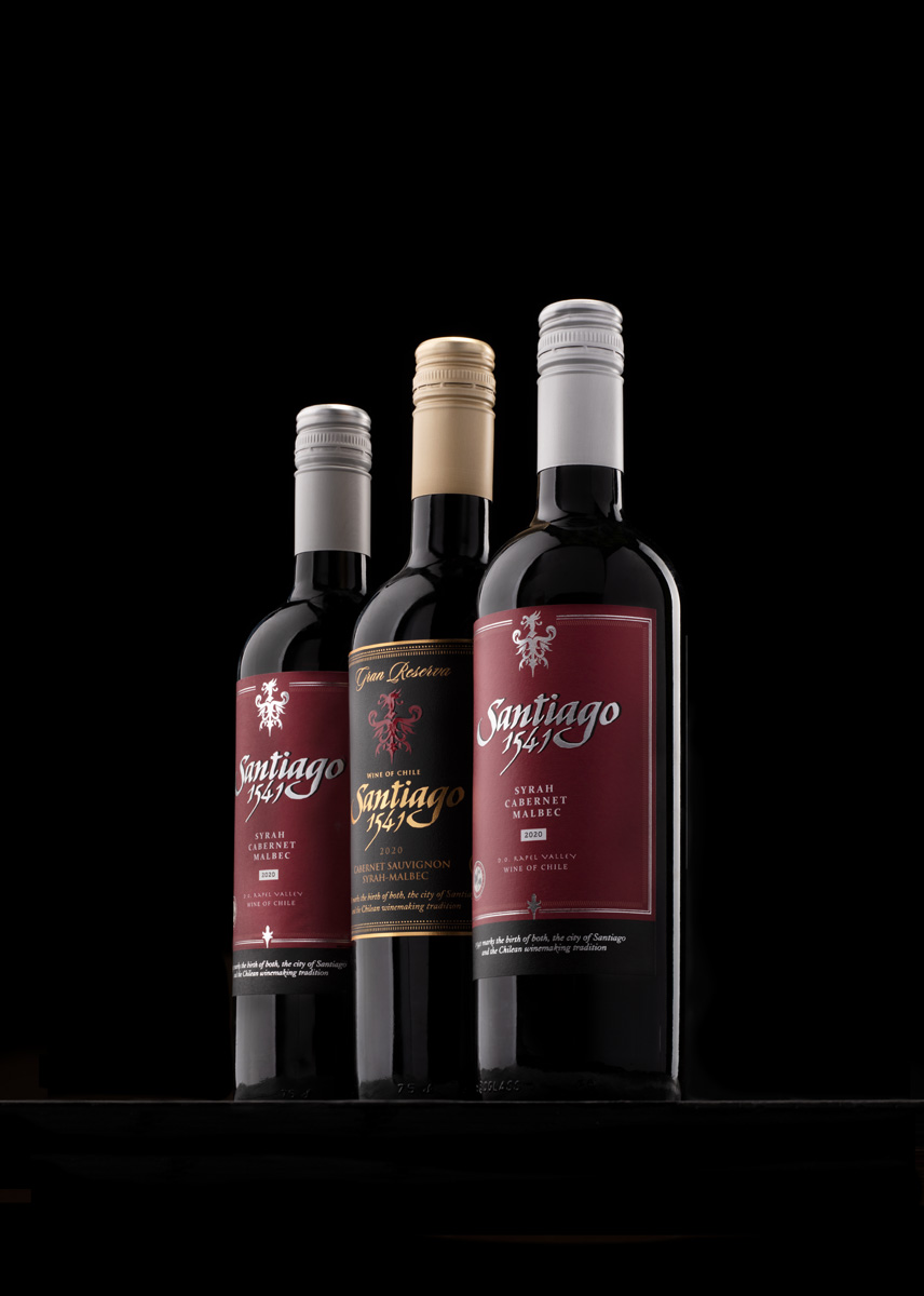 three wine bottles photographed on a black background by Tomas Olsen