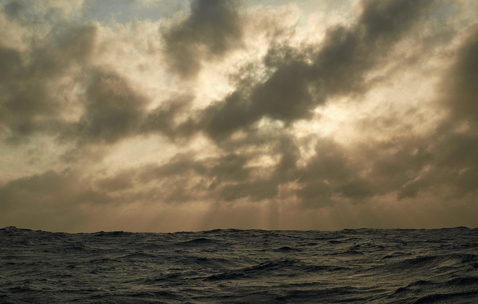 Sharp Sunrise is a photograph by Justus Järnefelt taken while sailing from Horta to Brest i May 2022. The sun is forcing itself through hazy clouds