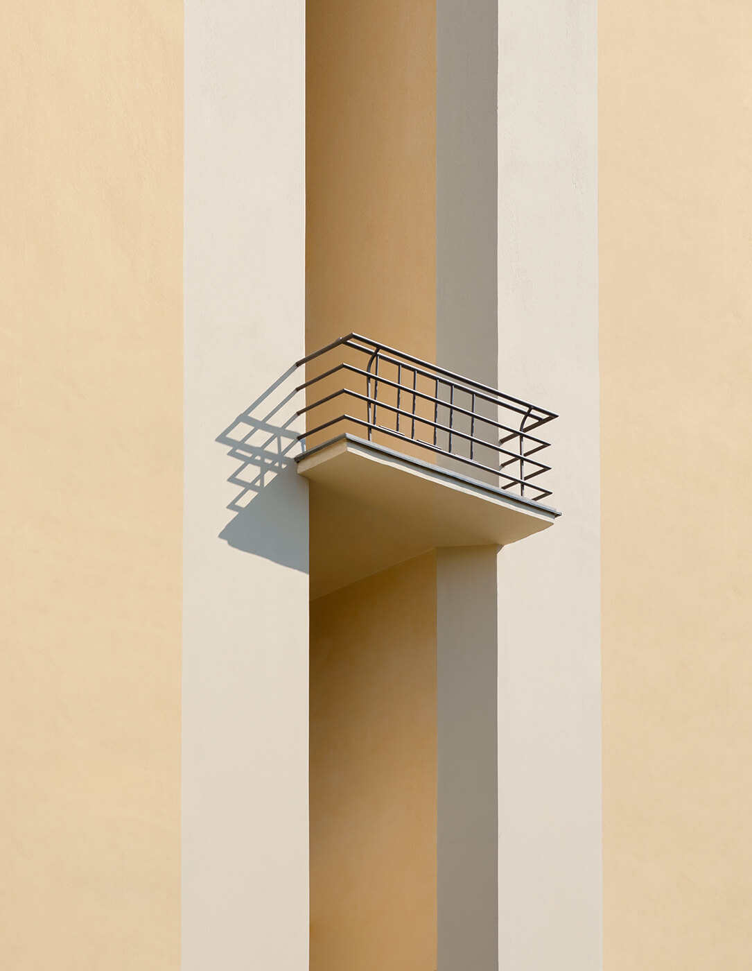 A minimalistic architectural image of a balcony in a yellow building