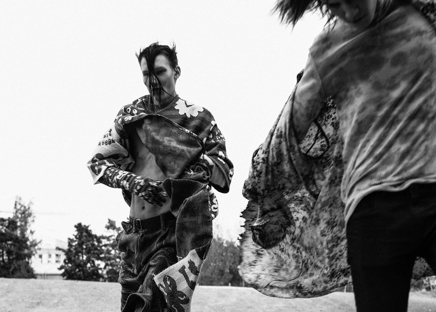 A black and white portrait of two young punk men running outdoors