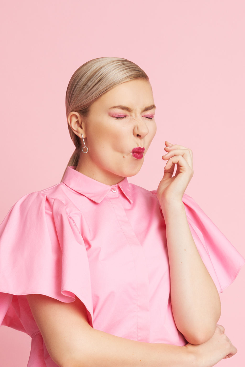 Portrait_of_Blond_Young_Woman_Making_Funny_Face_on_Pink_Backdrop_for_Muud_Creative_by_Sara_Lehtomaa