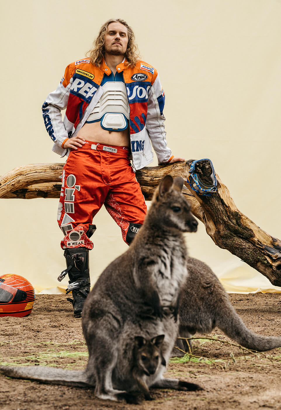 A portrait of a man wearing motocross gear posing with kangaroos