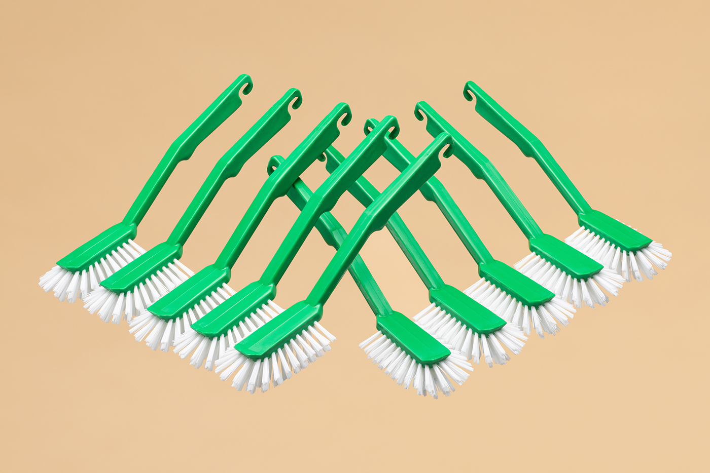 Dish brushes arranged in a graphical formation on a beige background by Tomas Olsen